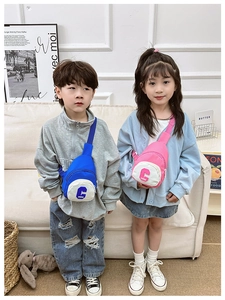 Blue and pink canvas chest bags with 'C' embroidery shown by children in a home setting