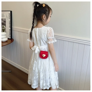 Close-up of intricate floral embroidery and lace trim on a white puff sleeve dress