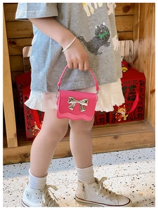 Pink mini handbag for kids featuring a silver bow and decorative scalloped edge detail