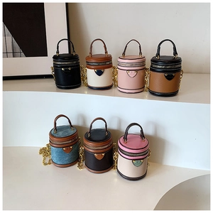 Detailansicht der Mini-Zylindertaschen mit Kontrastnähten und goldener Gliederkette