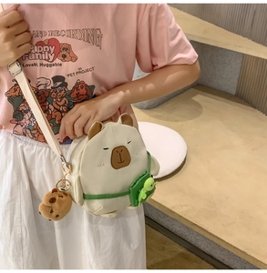 Close-up of cute plush capybara crossbody bag with turtle charm and adjustable strap