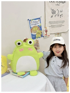 Detail of cute green frog backpack for children featuring 3D eyes and canvas texture