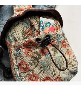 Détail du sac bandoulière en jacquard fleuri avec cordon de serrage et poche avant