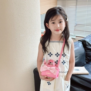Pink mini crossbody bag for kids featuring a large bow and adjustable shoulder strap