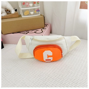 Detail of kids chest bag with orange and white contrast color and letter C embroidery