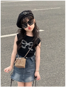 Détail d'un mini sac à chaîne matelassé marron avec rivets pour tenues d'enfants stylées