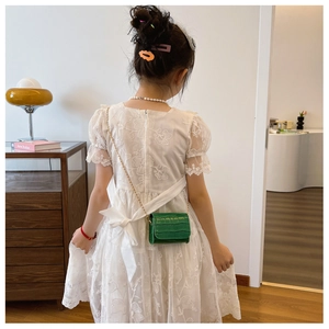 Girl wearing a green stone texture mini crossbody bag with a delicate gold chain strap