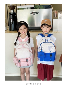 Close-up of children backpack set featuring UP letters and matching small hanging bags