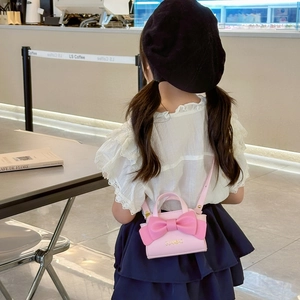 Pink mini crossbody bag for kids with large bow detail and elegant handle