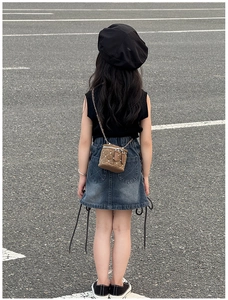 Vue de dos d'un enfant portant un mini sac seau marron à rivets et bandoulière