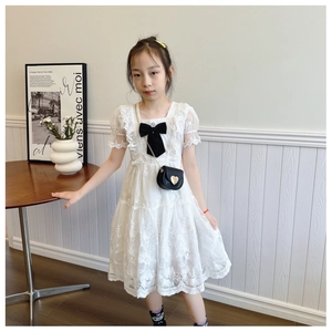 Detail of white lace dress with floral embroidery and a heart-shaped chain bag for girls