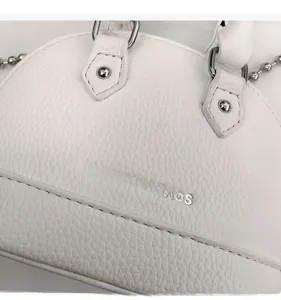 Close-up of white lychee texture shell bag with silver FASHION & BAGS metal logo