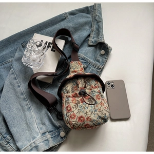 Détail du sac bandoulière en jacquard floral avec motifs de fleurs et cordon de serrage