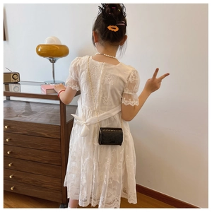Detail of white lace dress back featuring floral embroidery and a satin bow tie