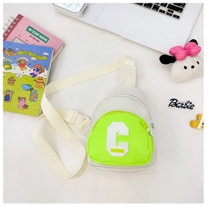 Close-up of kids crossbody bag with neon green zipper pocket and bold letter C print