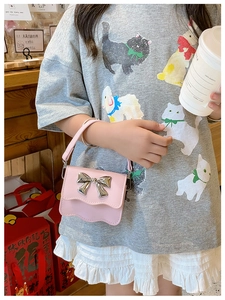Child girl wearing pink PU handbag with silver metal bow and wavy edge details