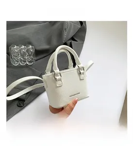 Close-up of white mini square bag with lychee texture and silver metal hardware