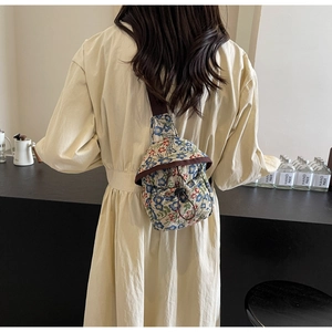 Sac bandoulière floral avec cordon de serrage porté par un mannequin en intérieur chic