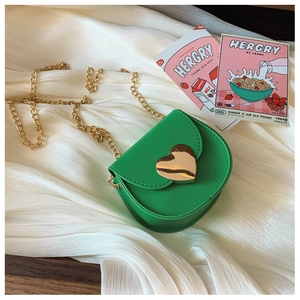 Detail view of mini green kids crossbody bag with golden heart clasp and chain strap