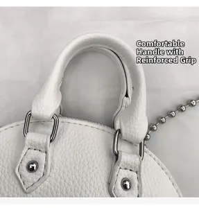 Detail of white lychee leather handbag handle with silver D-rings and sturdy rivets