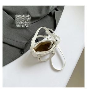 Top view of small white litchi pattern handbag showing internal zipper pocket and beige lining