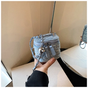 Gros plan du mini sac boîte en denim bleu clair avec motif matelassé et chaîne