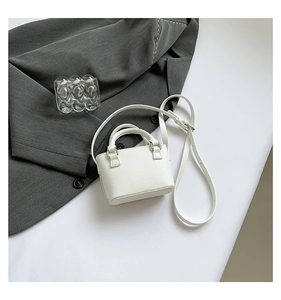 Detailed macro view of white pebbled leather mini square handbag with silver hardware