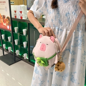 Pink Capybara plush crossbody bag with green turtle and cookie charms on model