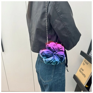 Detailed macro of a flower-shaped crossbody bag featuring gradient metallic purple and blue
