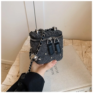 Détail d'un mini sac seau en denim avec matelassage en strass et bandoulière en chaîne