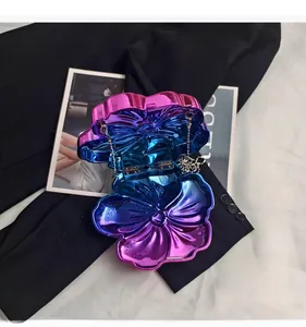 Close-up of metallic gradient flower clutch with chain on black and white texture
