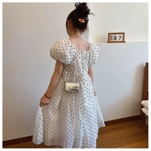 Detailed back view of girls' white polka dot dress with short puff sleeves and hidden zipper