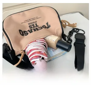 Top view of beige canvas crossbody bag showing large capacity for umbrella and cosmetics