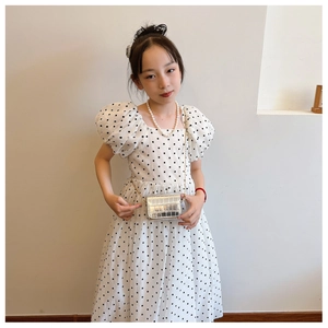 Detail of silver stone pattern chain bag styled with white polka dot princess dress