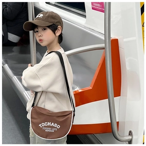 Détail d'un sac bandoulière en nylon marron et casquette assortie avec texte YOUNG LIFE