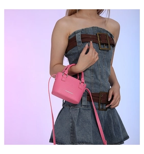 Pink lychee grain mini crossbody bag with Fashion & Bags logo worn by a model