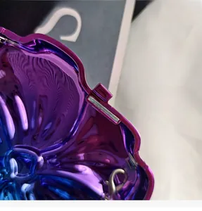 Close-up of iridescent purple and blue gradient metal hardware with a wave texture and magnetic clasp