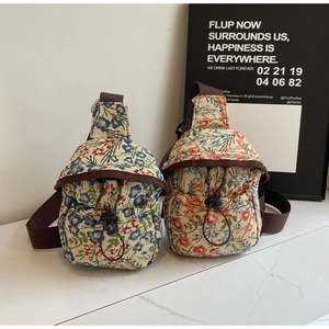 Détail de sacs bandoulière en jacquard fleuri avec rabat à cordon et sangle réglable