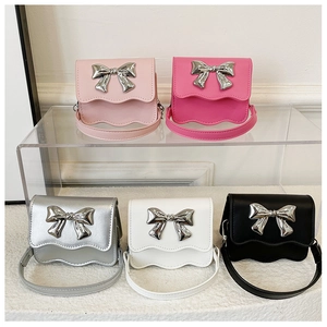 Detailed view of colorful mini kids bags with wavy edges and metallic silver bows