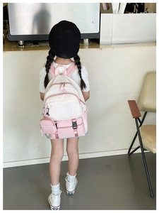 Pink and beige children backpack with UP logo shown in a lifestyle indoor setting