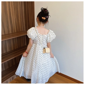 Detail showing the back of a French-style girl's polka dot dress with back zipper