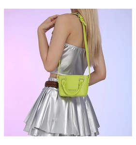 Neon green mini crossbody bag with lychee texture and silver lettering on Y2K model