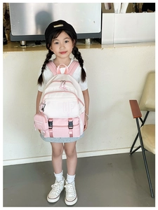 Detailed view of kids backpack with front pocket and hanging fashion coin purse accessory