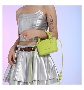 Close-up of neon green mini bag featuring lychee texture and white fashion text logo