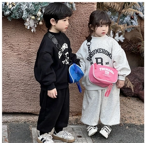 Close-up of kids wearing streetwear tracksuits with stylish canvas crossbody bags