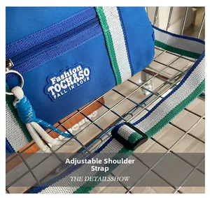 Détail de la bandoulière réglable en toile à rayures bleues avec boucle sur le sac enfant