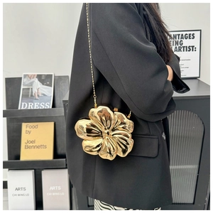 Close-up of golden 3D flower petal clutch bag with metallic chain strap and mirror finish