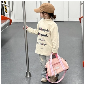 Détail du sac bandoulière rose en oxford avec étiquette mode et poignée à damier dans le métro