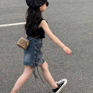 Sac à bandoulière enfant à rivets avec gilet noir élégant et jupe en jean tendance