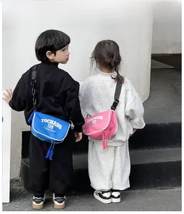 Rear view of kids wearing blue and pink canvas crossbody bags with adjustable straps